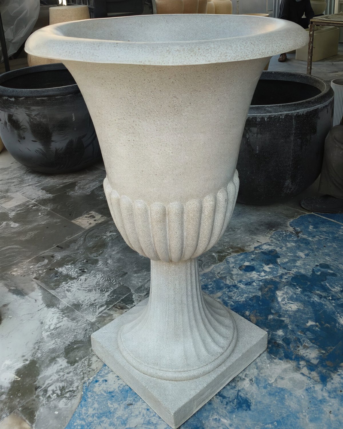Lutyens Victorian-style European planter in rustic light grey fiberglass, styled in a garden setting